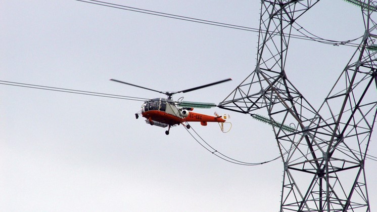 Helicóptero llevando cable de alta tensión